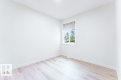 Bright room featuring light wood-finish flooring, white walls, and a recessed ceiling light - 