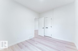 Bright interior space featuring light wood-finish flooring, white baseboards, and a white wall finish - 