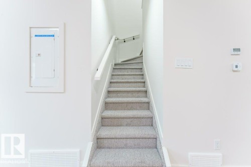Carpeted staircase with white risers and a white handrail - 6920/6922 106 Street, Edmonton, AB - Indoor Photo Showing Other Room