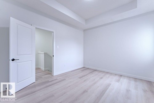 Bright room featuring light wood-finish flooring, crisp white walls, and a recessed ceiling detail - 6920/6922 106 Street, Edmonton, AB - Indoor Photo Showing Other Room