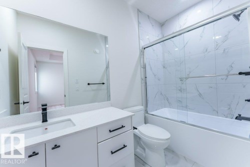 Contemporary bathroom featuring a white vanity with a rectangular undermount sink, a matte black faucet, and matching hardware - 6920/6922 106 Street, Edmonton, AB - Indoor Photo Showing Bathroom