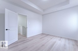 Bright room featuring light wood-finish flooring, crisp white walls, and a recessed ceiling detail - 
