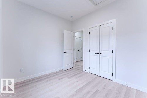 White interior walls with light wood-finish flooring - 6920/6922 106 Street, Edmonton, AB - Indoor