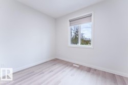 Room featuring light wood-finish flooring, white walls, and white baseboards - 