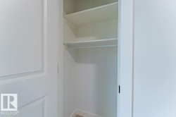 White interior closet featuring multiple shelves and a hanging rod - 