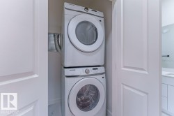 Stackable washer and dryer unit with white cabinet doors - 