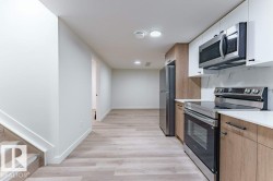 Compact kitchen featuring stainless steel appliances, white countertops, and two-tone cabinetry - 