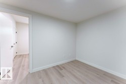 Bright interior space featuring light wood-finish flooring, white walls, and a white baseboard trim - 