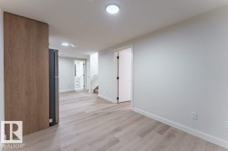 Open-concept room featuring light wood-finish flooring, recessed lighting, and crisp white walls - 