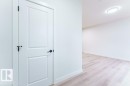 White interior door with black hardware, white baseboards, and wood-finish flooring - 6920/6922 106 Street, Edmonton, AB  - Indoor Photo Showing Other Room 