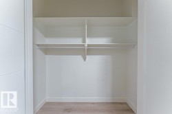 Spacious closet featuring two integrated shelves, a hanging rod, and wood-finish flooring - 