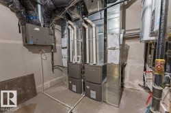 Utility room featuring multiple HVAC units and associated ductwork - 