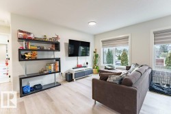 Bright living area featuring light wood-finish flooring, recessed lighting, and white walls - 