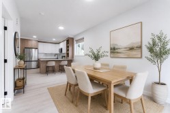 Open-concept dining area with wood-finish flooring extending into the kitchen - 