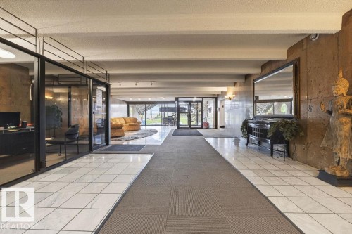 Spacious lobby featuring polished white tile flooring, a large area rug, and an expansive glass storefront - 1208 9918 101 Street, Edmonton, AB - Indoor Photo Showing Other Room