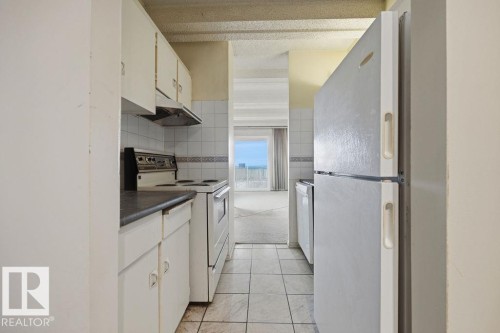 Galley kitchen featuring white cabinetry, a white electric range, and a white refrigerator - 1208 9918 101 Street, Edmonton, AB - Indoor Photo Showing Kitchen