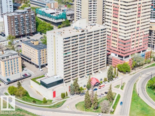 High-rise residential building featuring multiple balconies on each level, a flat roofline, and a multi-story base with a green rooftop area - 1208 9918 101 Street, Edmonton, AB - Outdoor With Facade
