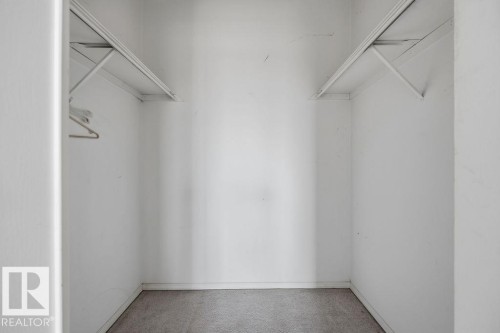 Walk-in closet with white walls and grey carpet flooring - 1208 9918 101 Street, Edmonton, AB - Indoor With Storage