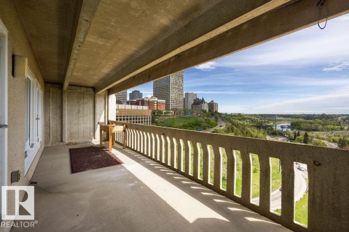 Expansive concrete balcony featuring a concrete floor, concrete railing, and a cityscape and natural landscape backdrop - 1208 9918 101 Street, Edmonton, AB - Outdoor With Exterior
