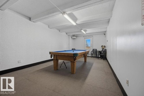 Recreational space featuring a full-size billiards table with a blue felt surface, wood-finish base, and integrated ball return system - 1208 9918 101 Street, Edmonton, AB - Indoor Photo Showing Other Room