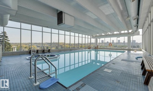 Indoor swimming pool featuring a large rectangular pool and a separate circular hot tub - 1208 9918 101 Street, Edmonton, AB - Indoor Photo Showing Other Room With In Ground Pool