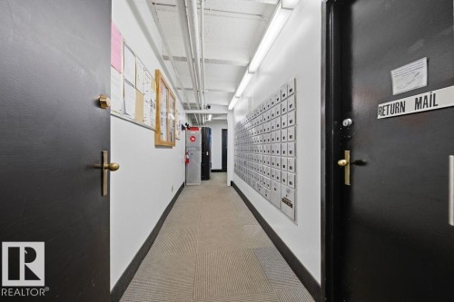 Centralized mailboxes in a well-lit corridor with durable carpet flooring and bright white walls - 1208 9918 101 Street, Edmonton, AB - Indoor Photo Showing Other Room