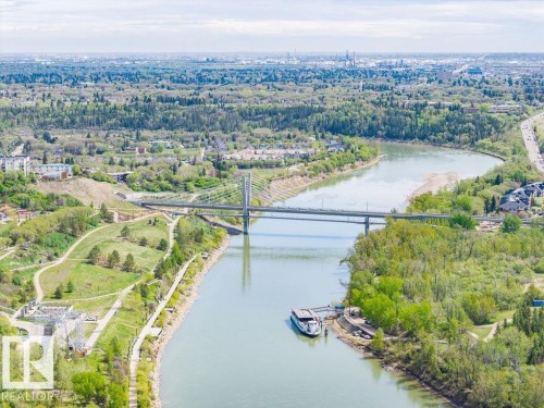 Aerial perspective showcasing a broad river winding through a densely treed landscape - 1208 9918 101 Street, Edmonton, AB - Outdoor With Body Of Water With View