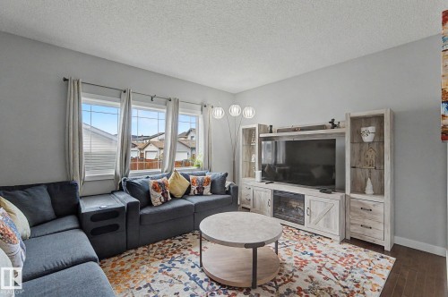 Bright living area featuring multiple windows, hard surface flooring, and a built-in media console with storage - 18144 76 Street, Edmonton, AB - Indoor Photo Showing Living Room