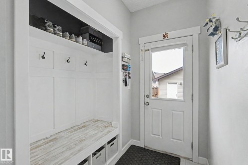 Entryway featuring built-in storage with a wood-finish bench, coat hooks, and a top shelf - 18144 76 Street, Edmonton, AB - Indoor Photo Showing Other Room