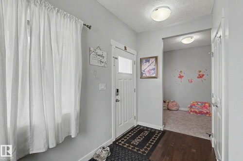 Entryway featuring dark wood-finish flooring and a white paneled door with an integrated window - 18144 76 Street, Edmonton, AB - Indoor Photo Showing Other Room