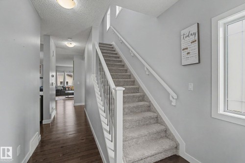 Carpeted staircase with white balusters and handrails - 18144 76 Street, Edmonton, AB - Indoor Photo Showing Other Room