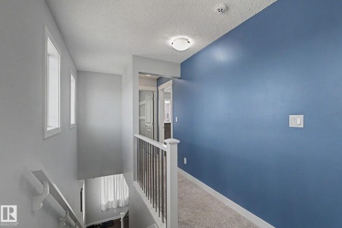Upper-level hallway featuring a textured ceiling, flush-mount lighting, and carpet flooring - 18144 76 Street, Edmonton, AB - Indoor Photo Showing Other Room