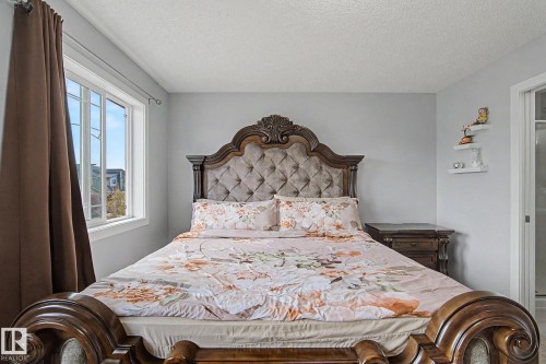 Bedroom featuring light gray walls, a window with white trim, and a textured ceiling - 18144 76 Street, Edmonton, AB - Indoor Photo Showing Bedroom