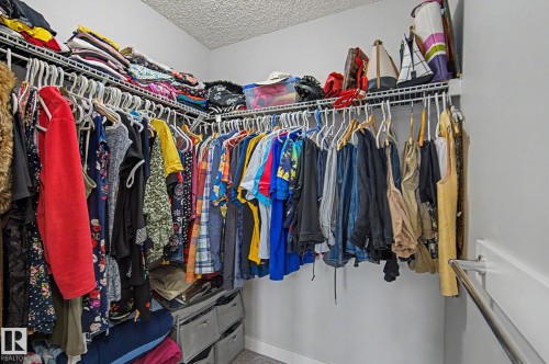 Walk-in closet featuring wire shelving, multiple hanging rods, and light gray wall paint - 18144 76 Street, Edmonton, AB - Indoor With Storage