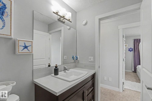 Bathroom vanity featuring a rectangular undermount sink, a stone-finish countertop, and a dark wood-finish cabinet with chrome hardware - 18144 76 Street, Edmonton, AB - Indoor Photo Showing Bathroom