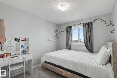 Bedroom featuring light gray walls, gray carpet flooring, and a single window with gray curtains - 18144 76 Street, Edmonton, AB - Indoor Photo Showing Bedroom