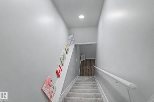 Carpeted staircase with light gray walls, a white handrail, and a recessed ceiling light - 18144 76 Street, Edmonton, AB - Indoor Photo Showing Other Room