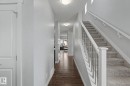 Entryway featuring wood-finish flooring, light grey painted walls, and a carpeted staircase with white railings and metal spindles - 18144 76 Street, Edmonton, AB  - Indoor Photo Showing Other Room 