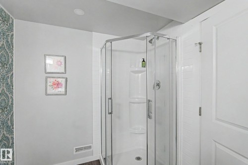Corner glass-enclosed shower featuring a white base and a built-in shelf - 18144 76 Street, Edmonton, AB - Indoor Photo Showing Bathroom