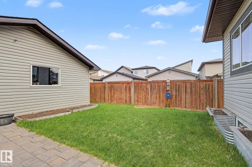 Private backyard featuring a wooden fence, green lawn, and paver patio - 18144 76 Street, Edmonton, AB - Outdoor With Exterior
