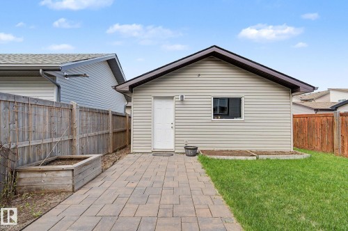 Detached rear garage featuring light-colored horizontal siding, a dark roofline, and a single white entry door - 18144 76 Street, Edmonton, AB - Outdoor With Exterior
