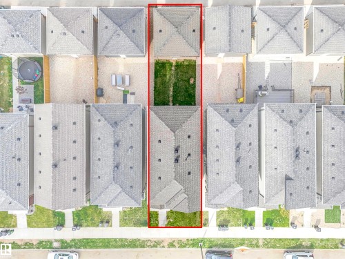 Aerial perspective highlighting the property outlined in red, featuring a rectangular lot with a residential structure and a grassy rear yard - 1518 Siskin Link Link, Edmonton, AB - Other