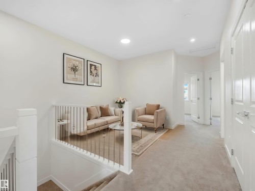 Upper-level landing featuring a white railing with vertical balusters, light-colored carpeting, and recessed lighting - 1518 Siskin Link Link, Edmonton, AB - Indoor Photo Showing Other Room