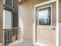 Entryway featuring a decorative glass door, light-colored siding, and a metal railing - 1518 Siskin Link Link, Edmonton, AB  - Outdoor With Exterior 