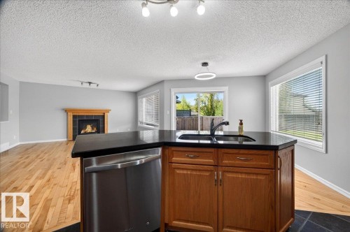 83 Becker Crescent, Fort Saskatchewan, AB - Indoor Photo Showing Kitchen With Fireplace With Double Sink