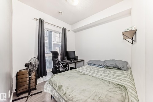 Bright bedroom featuring a single window, hard-surface flooring, and a compact wall shelf - 316 10518 113 Street, Edmonton, AB - Indoor Photo Showing Bedroom
