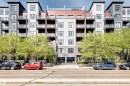 Modern multi-story building featuring a diverse facade of gray and dark gray panels, brick elements, and large windows - 316 10518 113 Street, Edmonton, AB  - Outdoor With Balcony With Facade 