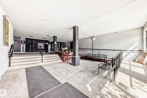 Foyer featuring light-toned tile flooring, recessed lighting, and black metal railings - 316 10518 113 Street, Edmonton, AB -  Photo Showing Other Room