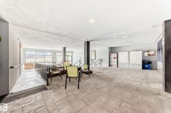 Spacious common area featuring textured concrete flooring and recessed lighting - 