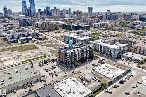 Urban landscape featuring a prominent high-rise building, dense commercial structures, street parking, and undeveloped parcels - 316 10518 113 Street, Edmonton, AB - Outdoor With View